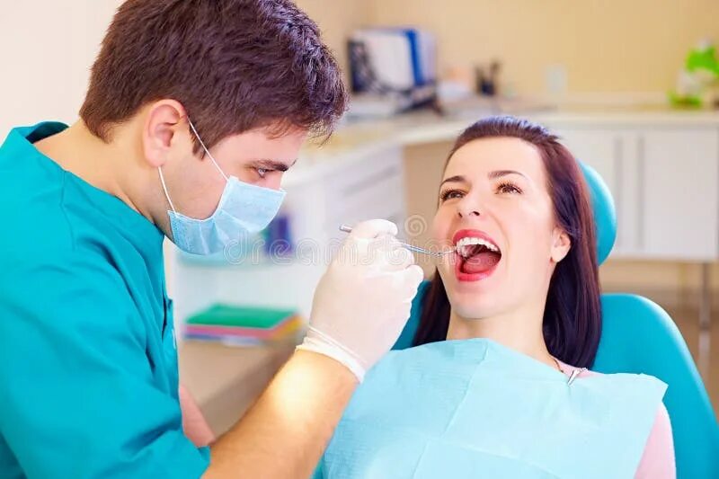 Врач занимающийся языком. Портрет стоматолога. Молодая женщина стоматолог. Фотография стоматолога изо рта. Врач который занимается деснами.