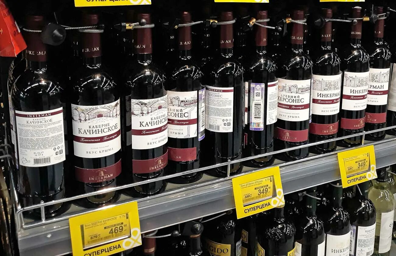 Купить вино в магазине красное. Вино в магазине. Дешевое российское вино. Красное вино с белой этикеткой. Ценник на вино.