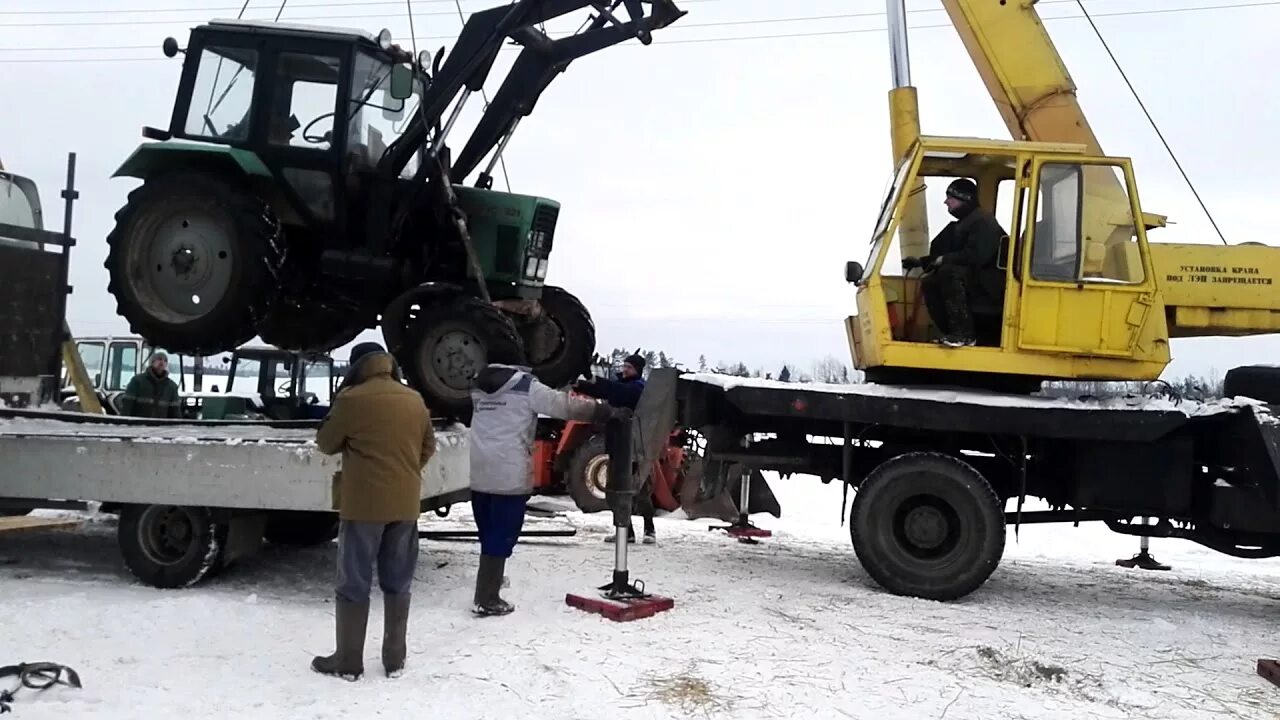 Трактора грузят. Погрузка трактора МТЗ краном в КАМАЗ. Разгрузка трактора. Автокран трактор. Разгрузка трактора краном.