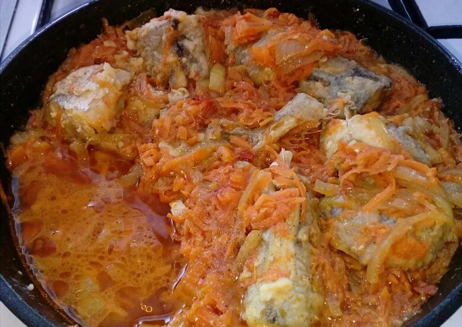 Минтай в кастрюле с луком и морковью. Минтай тушеный. минтай тушеный с морковью и луком. минтай с морковью и луком. минтай в луково-морковном соусе.