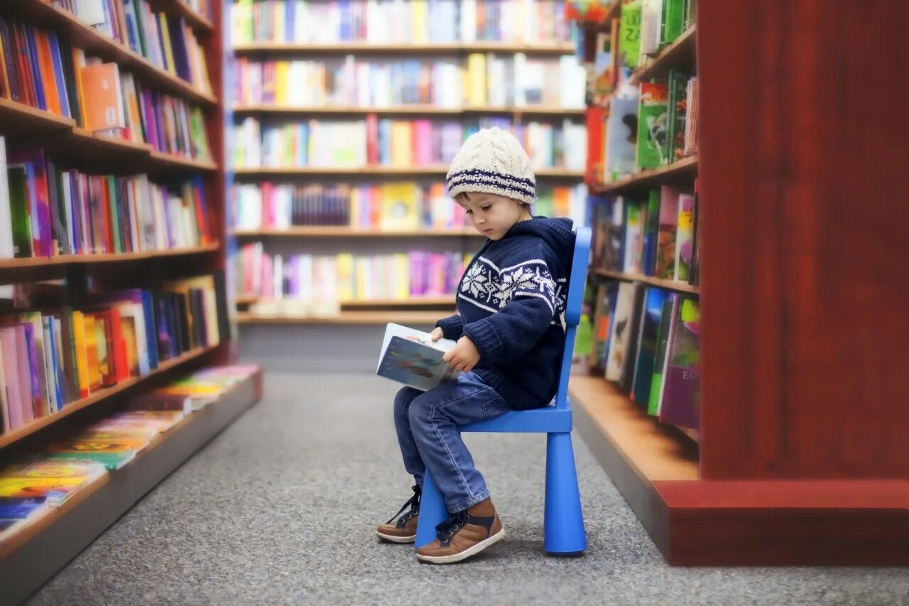 Чтение картинки. Дети в библиотеке. Библиотека для малышей. Книги для детей. Мальчик с книжкой в библиотеке.