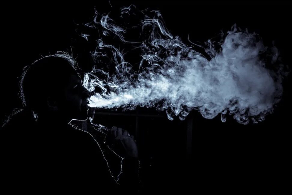 Красивый дым. Дым электронных сигарет. Пар от сигарет. Вейп на черном фоне.