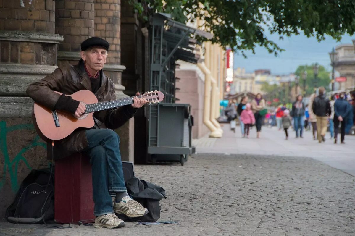 Поют на гитаре на улицах. Уличные музыканты. Музыканты на улице. Уличный гитарист. Уличный музыкант гитарист.