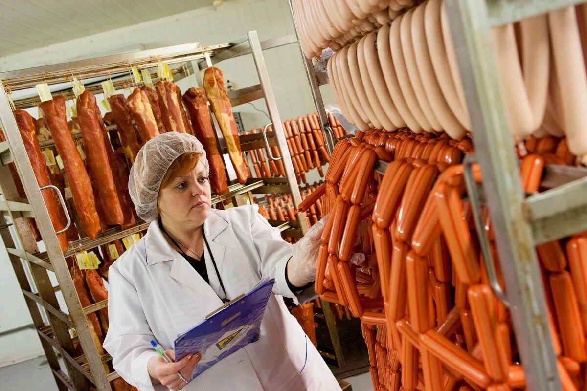 колбасный цех. фабрика колбасы. копчение колбасных изделий. колбасный завод. упаковщик колбасных изделий.