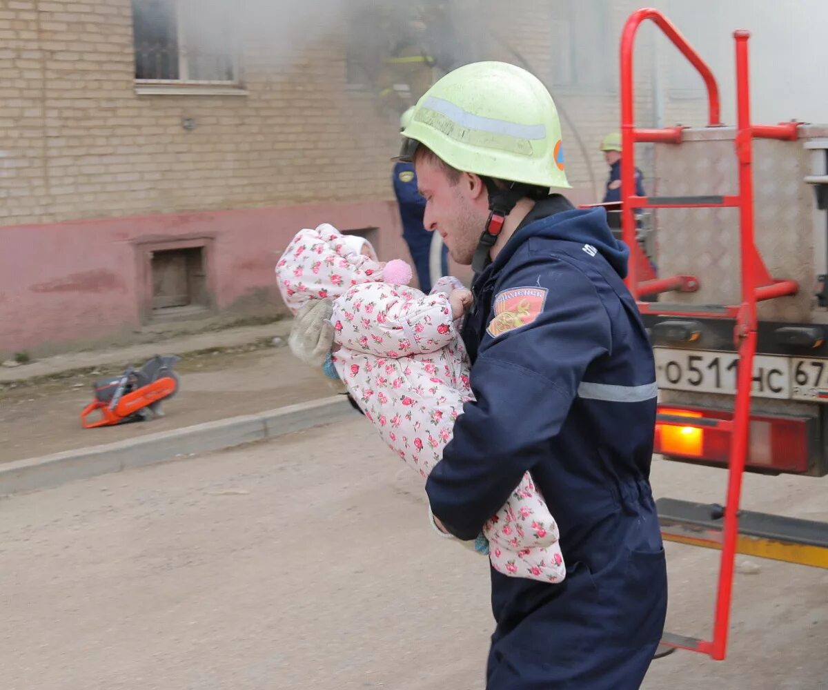 МЧС спасает детей. Пожарный спасает ребенка. Спасение детей из пожара. Пожарные на пожаре. Пожарный выносит