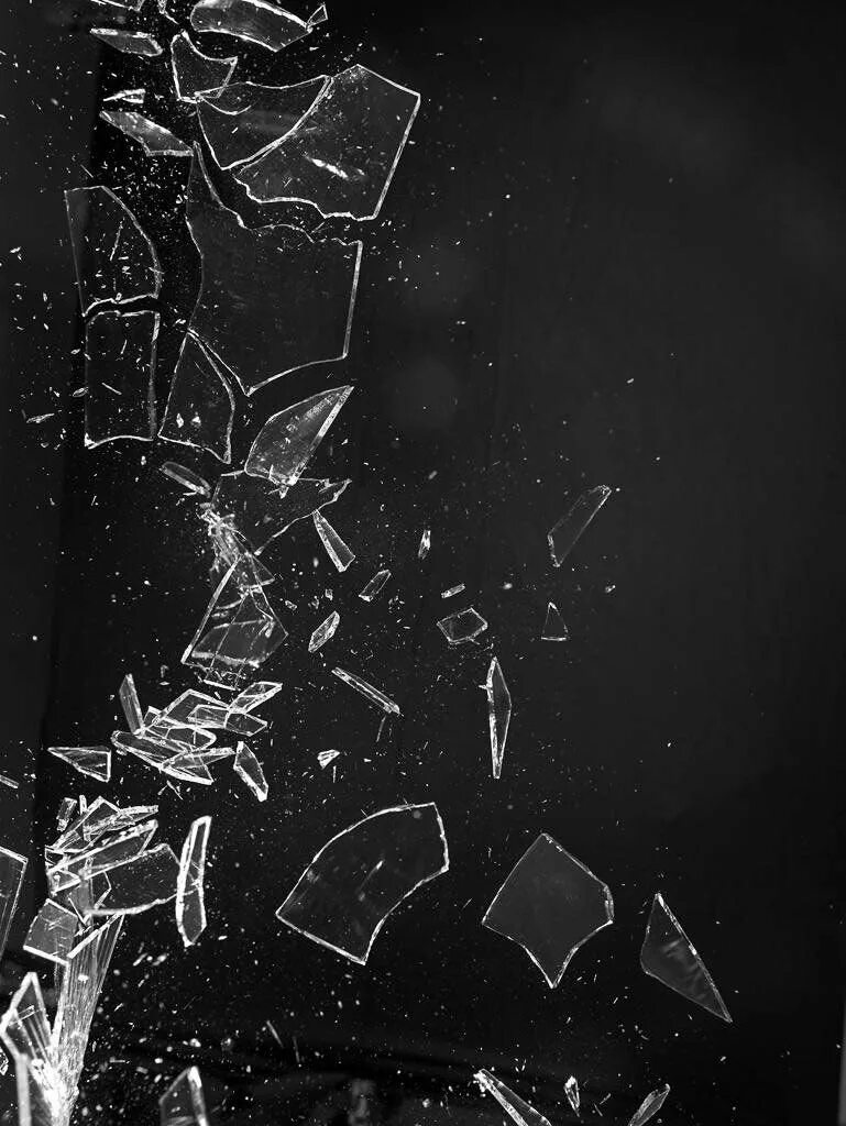 Кусок стекла. Кусок стекла. Разбитые куски стекла. Разбитое стекло на темном фоне. Осколки стекла.