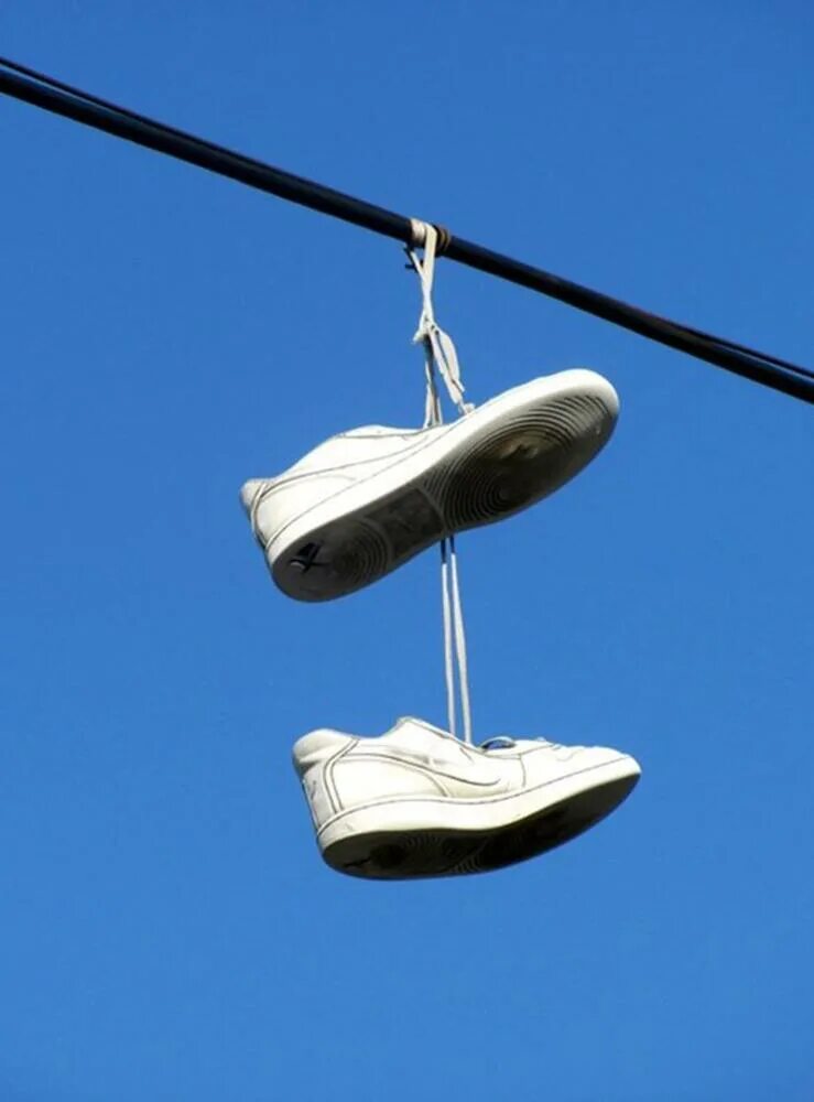 Зачем обувь на проводах. Кроссовки на проводах. Ботинки на проводах. Ботинки висят на проводах. Кроссовки на веревке.