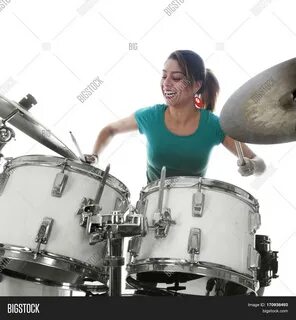 brunette brazilian woman has fun playing the drums in studio against white ...