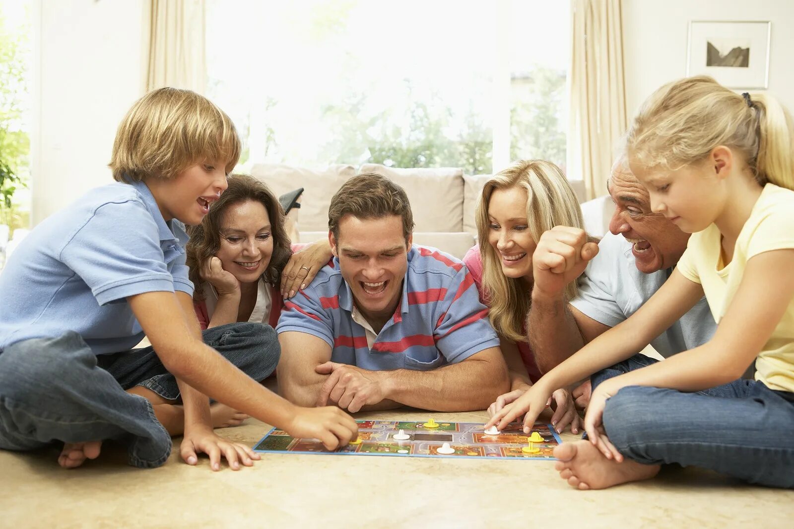 Вечер с семьей. Общение в кругу семьи. Времяпровождение с семьей. Семья играет в настольные игры. Семья за настольной игрой.