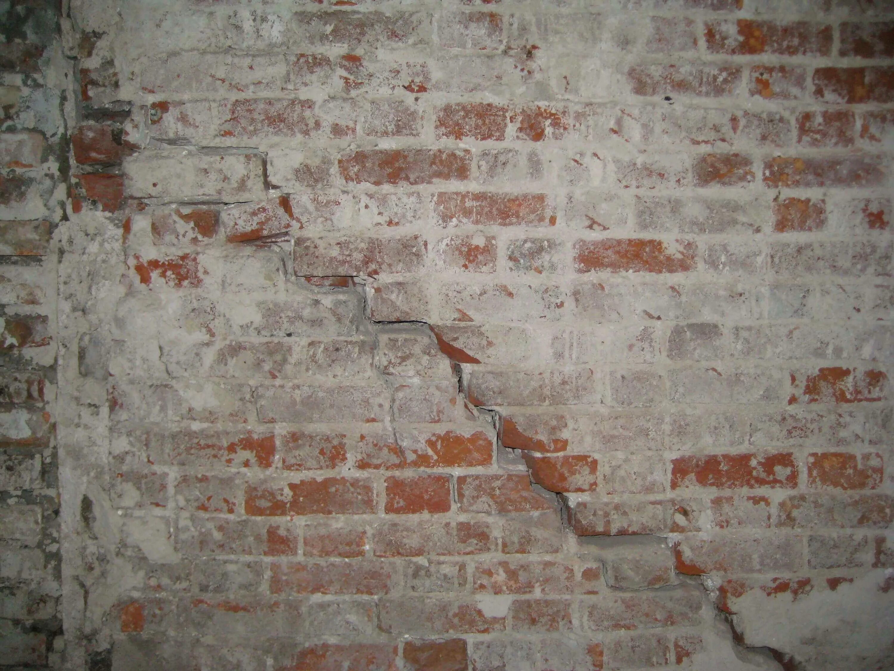 Трещины стены причины. Трещина в кирпичной стене. Трещины в кирпичной кладке. Трещины в каменных стенах. Трещины в кирпичных.