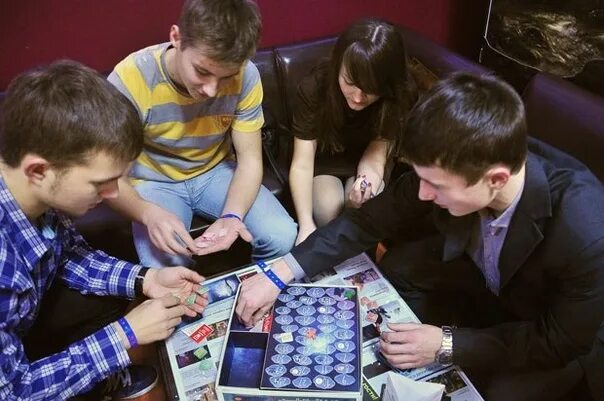 Настольные игры для молодежи. Кафе с настольными играми. Игроки в настольные игры. Веселая компания за столом. Настольные игры для детей.