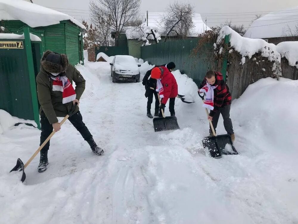Помощь снежку. Помощь пожилым в уборке снега. Волонтеры Пенза. Волонтеры помогают старикам силуэт убирать снег. Уборка снега волонтерами фото.