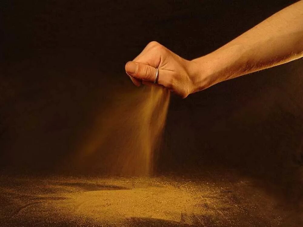 Сыплется. Песок в ладони. Песок в руках. Песок сыпется. Струйка песка.