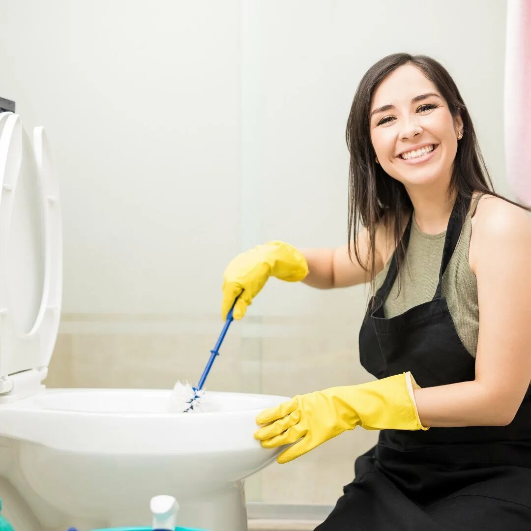Женщина дома в туалете. Девушка чистит сантехнику. Женщина за уборкой. Девушка чистит унитаз. Женщина чистит ванну.