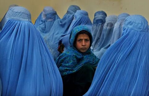 Afghan women wearing hijab or burqa wait in line in 2003. 