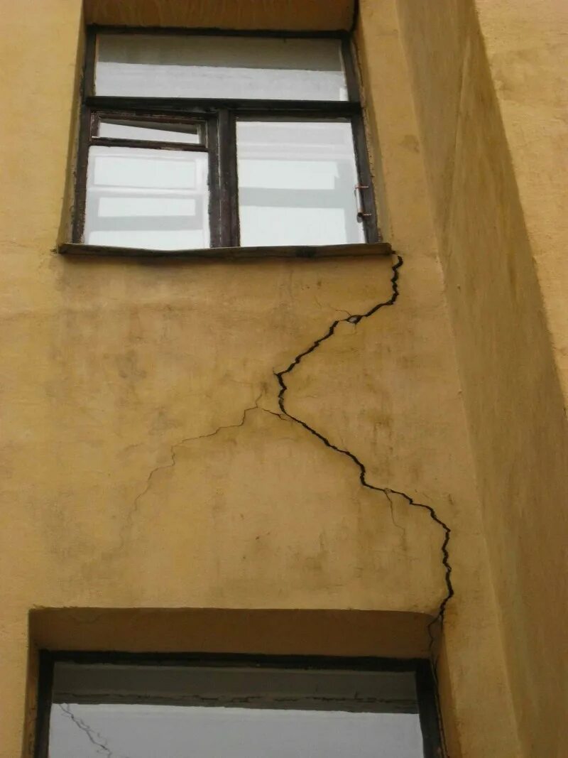 Трещина в стене. Трещины в стенах здания. Вертикальные трещины в стенах. Трещины в оконных проемах.