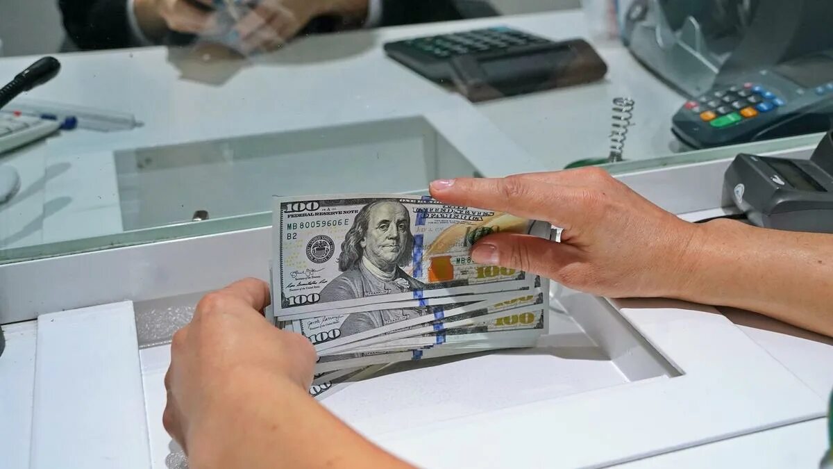 Т банк продать доллары. Подорожание валюты. кассир с деньгами. доллары пересчет.