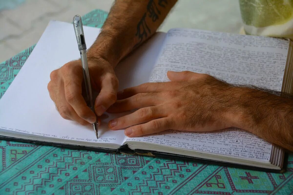 Писать полезно. Человек с ручкой в руке. Ручка пишет на бумаге. Мужская рука пишет. Руки с ручкой на столе.