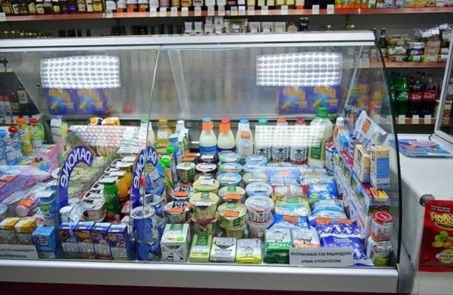 На прилавках магазинов лежат отборные. Витрина молочной продукции. Витрина продуктового магазина. Выкладка молочной продукции. Молочная продукция витрина.