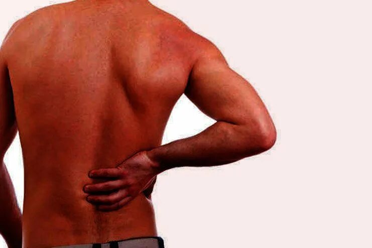 "Right back lower Base" 112.64.550.00. A young man is standing suffering from lower back Pain. Back area