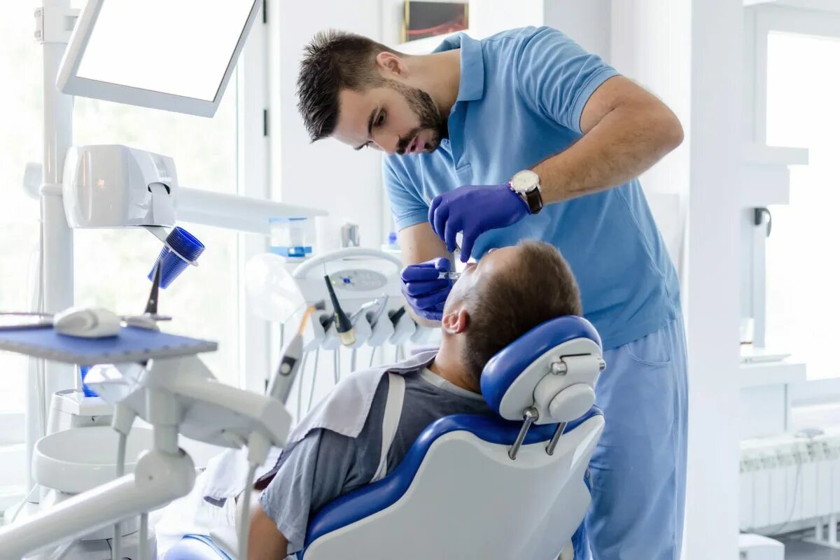 Зубной терапевт. Стоматолог мужчина. Врач стоматолог мужчина. Врач стоматолог и пациент. Зубной врач мужчина.