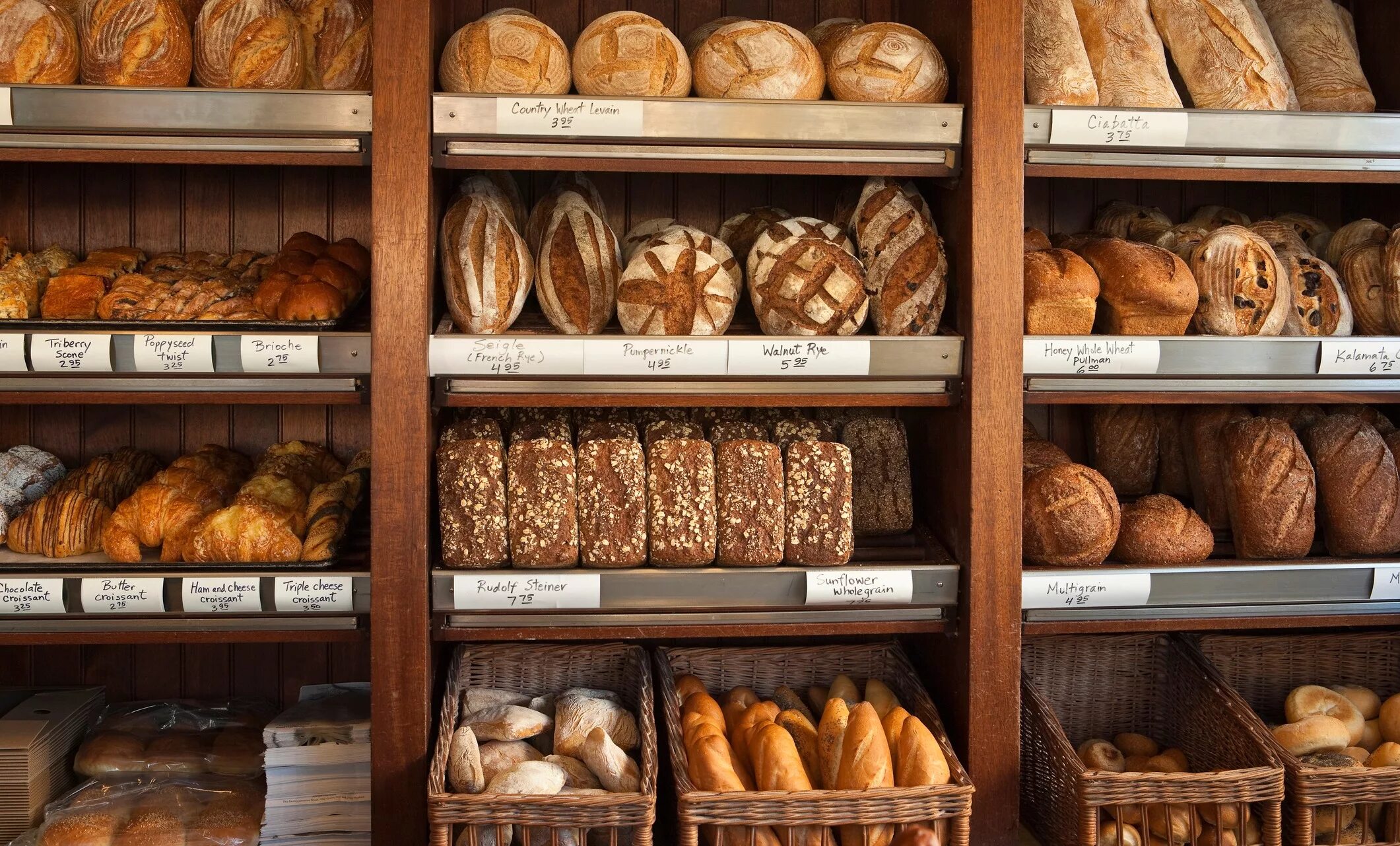 Хлеб сеть магазинов. Выкладка хлеба. Хлебный отдел. Витрина для хлебобулочных изделий. Хлебобулочные изделия на прилавке.