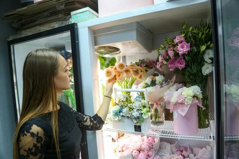 Продавец цветов в магазине. Продавец цветов. флорист в цветочном магазине. цветочный магазин псков. фото флориста за работой.
