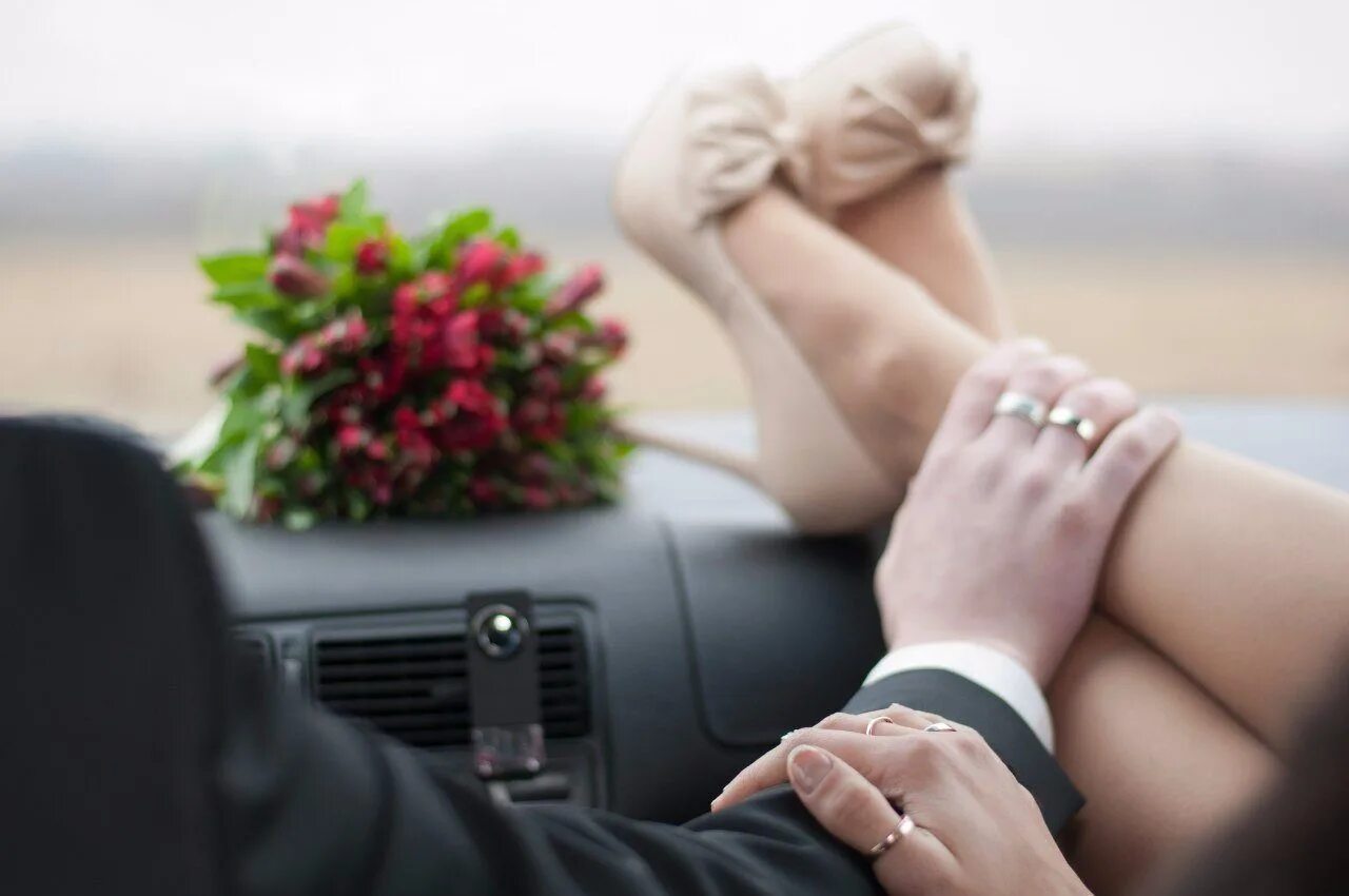 Муж целует ноги жене. Букет для мужчины. Руки влюбленных. Мужчина и женщина в машине. Влюбленные в машине.