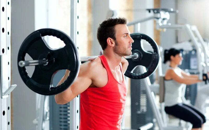 Тренажеры в зале. Спортзал. Мужчина в спортзале. Занятия в спортзале для мужчин. Мужчина на тренажере.