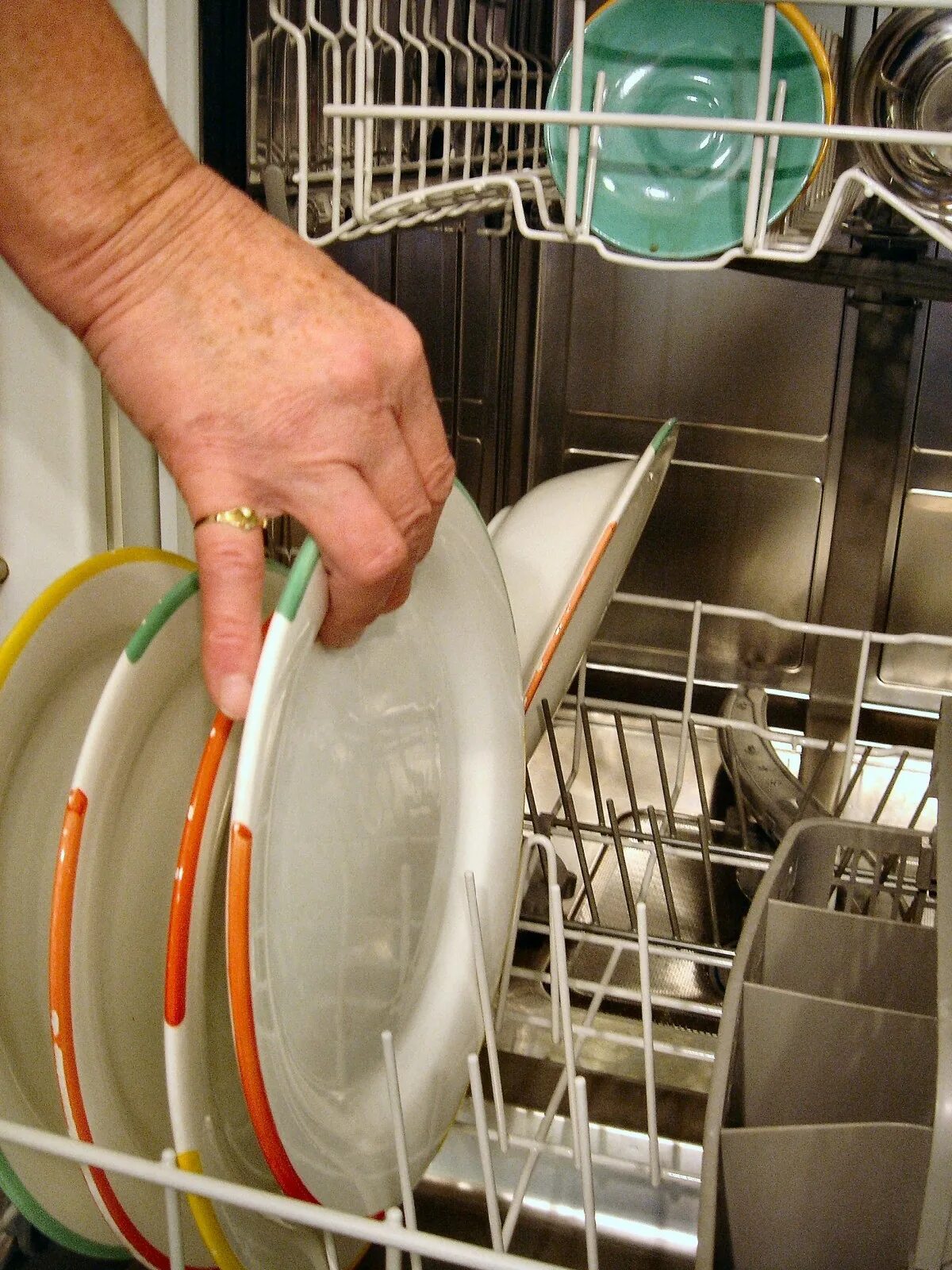Посуда в посудомойке. Посуда моющая машина. Загрузка посуды в посудомоечную машину. Посудомойка с грязной посудой.