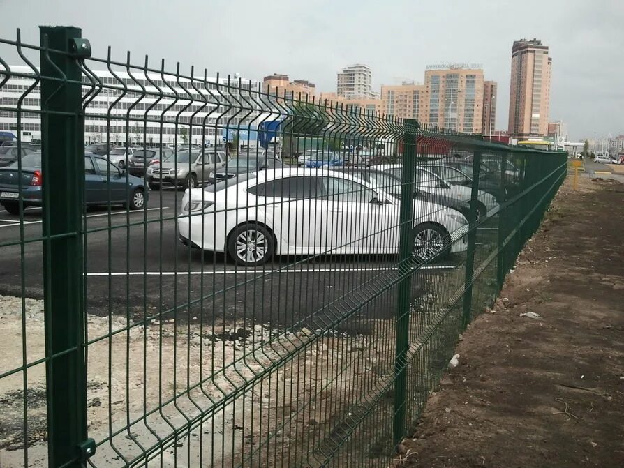Автостоянку оградили забором который имеет прямоугольную форму. Ворота из сетки гиттер 3 д. ограждение автостоянки. ограждения для парковки машин. автостоянка с забором.