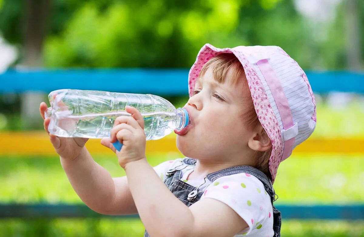 Дети пьют из бутылки. Дети воды. Питье летом в жару. Питье воды для детей. Ребенок пьет воду.