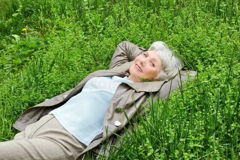 Женщина лежит на траве. Пожилая женщина отдыхает. Взрослая женщина лежит на траве. Женщина пожилая на траве. Старые женщины на природе