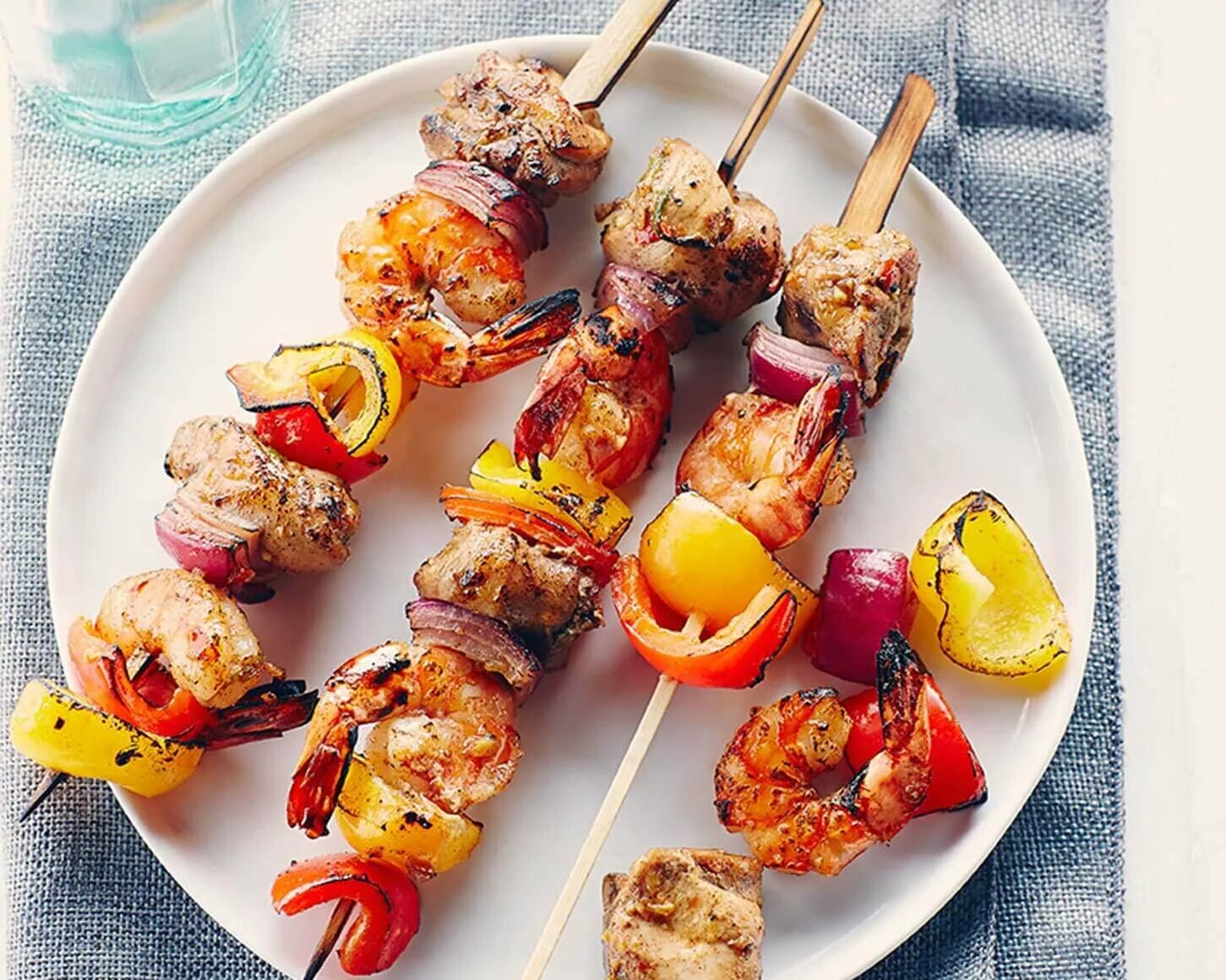 Шашлык из курицы в беконе. Шашлычок куриный тандури. морепродукты на шпажках. шашлычки из креветок. шашлык из морепродуктов на шпажках.