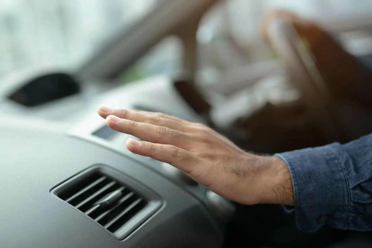 Car Air Conditioner. Air conditioning in the car. Heat in car. Мужик в машине с вентилятором. Hand checking