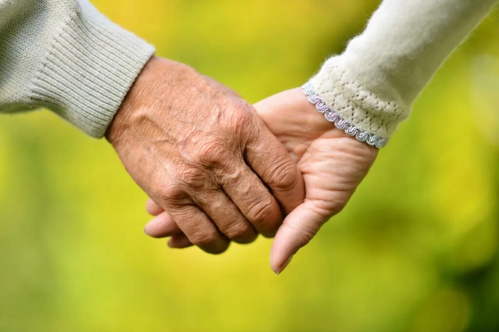 Пожилые держатся за руки. Руки пожилых супругов.