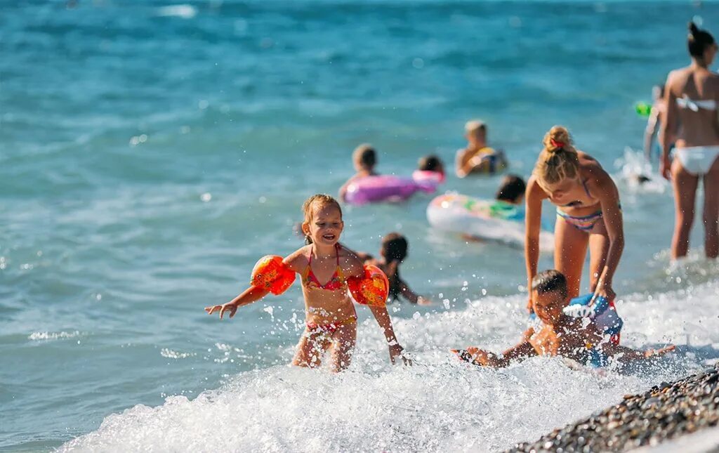 кноссос роял крит. малыши на пляже. пляж море люди. девушка на пляже. люди на пляже.