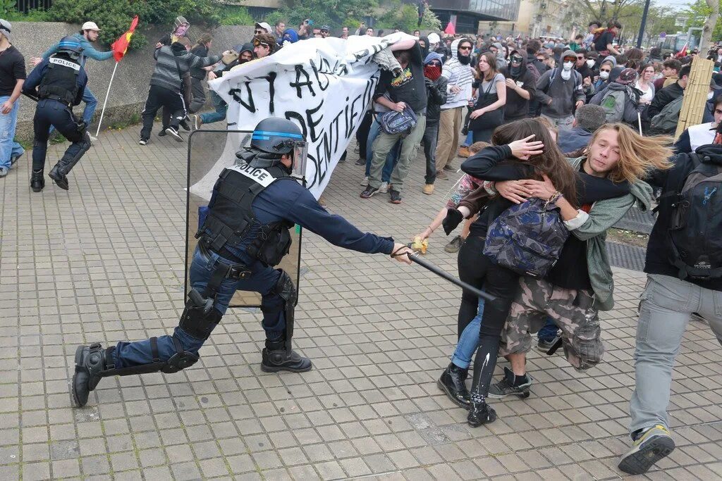 Мотоциклист в толпе феминисток. Полиция Франции разгоняет демонстрантов. Полиция Германии избивает демонстрантов. Разгон демонстрантов во Франции. Полиция Франции избивает демонстрантов.