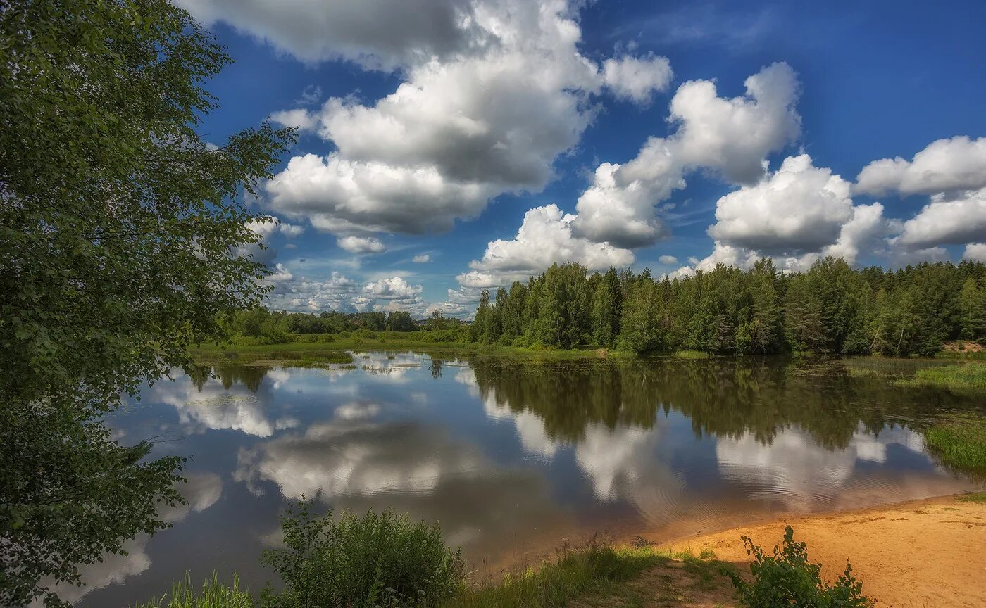 В реку смотрят облака. Облака в реке. Облака над рекой. Берег реки. Отражение неба в реке.