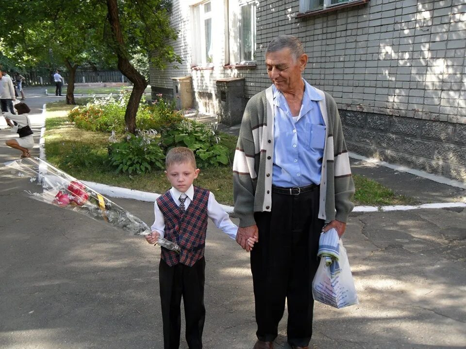 Внуки пошли в школу. Дедушка. Дедушка и внук. Дедушка ведет внука. Старик и внук.