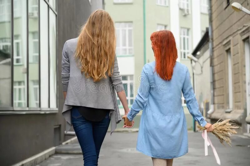 Пошли подруга. Две девушки идут за руку. Две девушки идут по улице. Две девушки идут со спины. 2 Женщины идут.