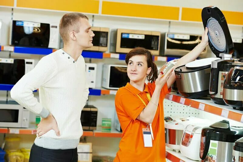 Товары в магазине техники. Продавец бытовой техники. Продавец в магазине техники. Продавец бытовой техники девушка. Консультант в магазине техники.