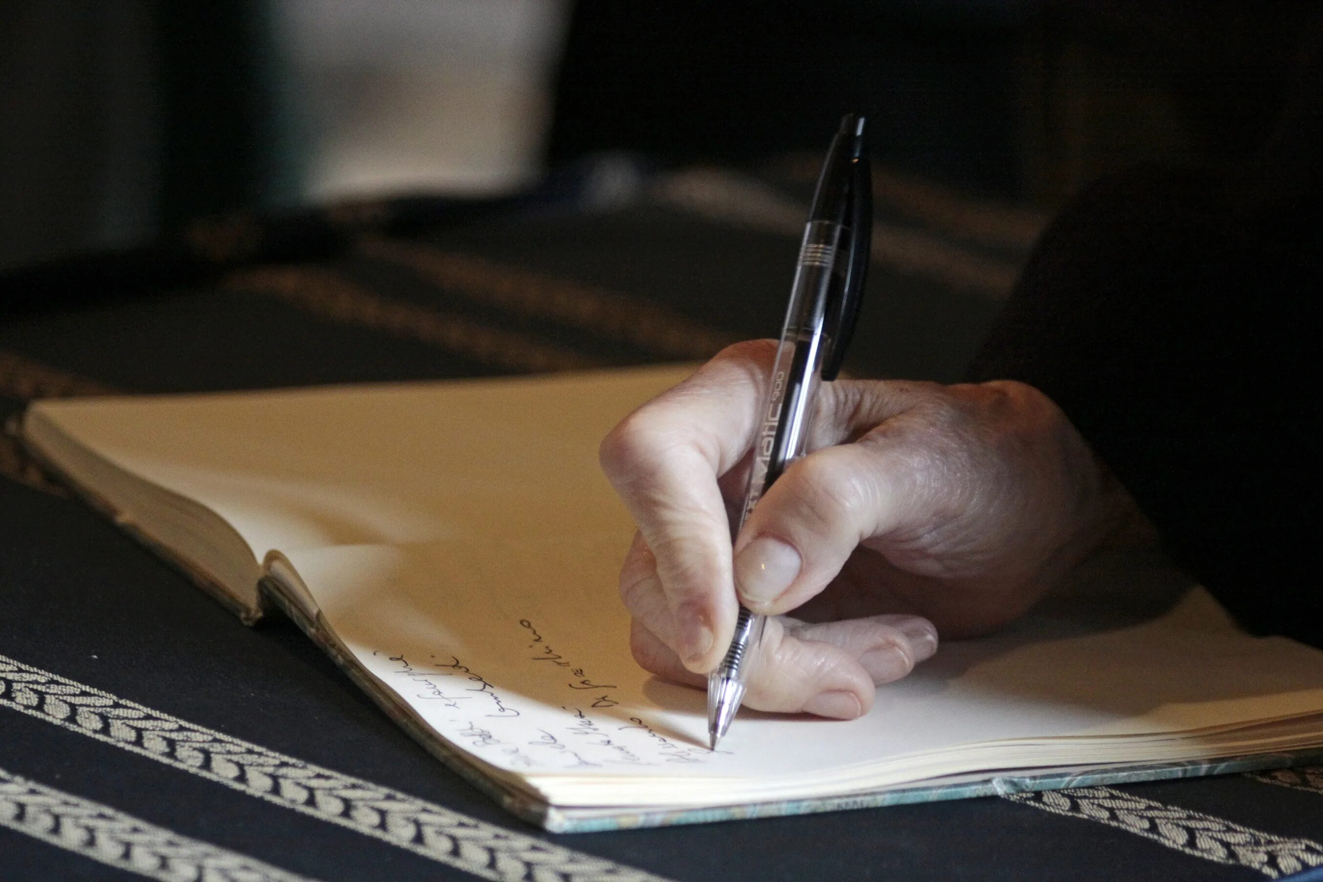 Человек пишет на листе бумаги. Человек с ручкой. Человек пишет письмо. Что записать в блокнот. Мужская рука пишет.