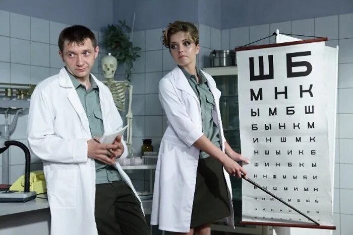 At the Optician. Young female optometrist with an universal messbrille in hand ,