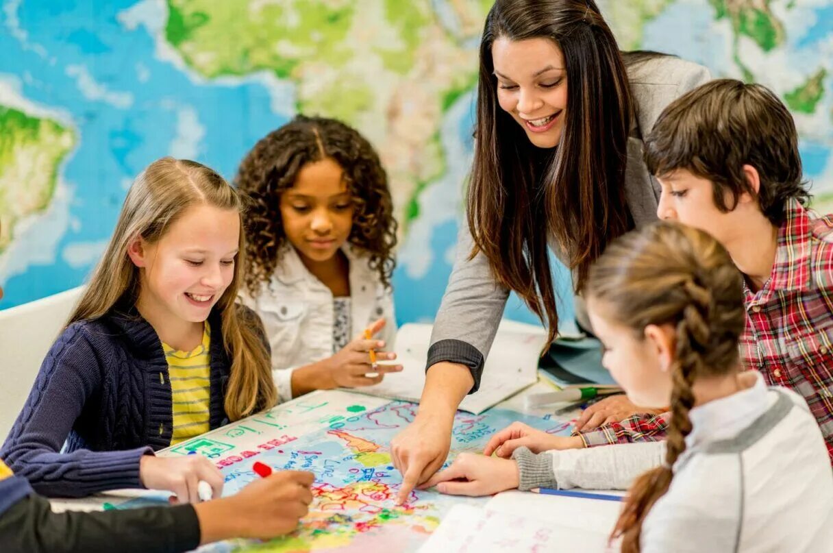 Экзамены в английских школах. Счастливый педагог с детьми. Fidgeting. Дети в компьютерном классе. Учитель и дети.