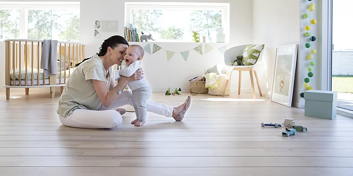 There are people in the room. Indoor playing Family. Indoor Air quality. Baby Room the Floor. Clean Air and Baby.