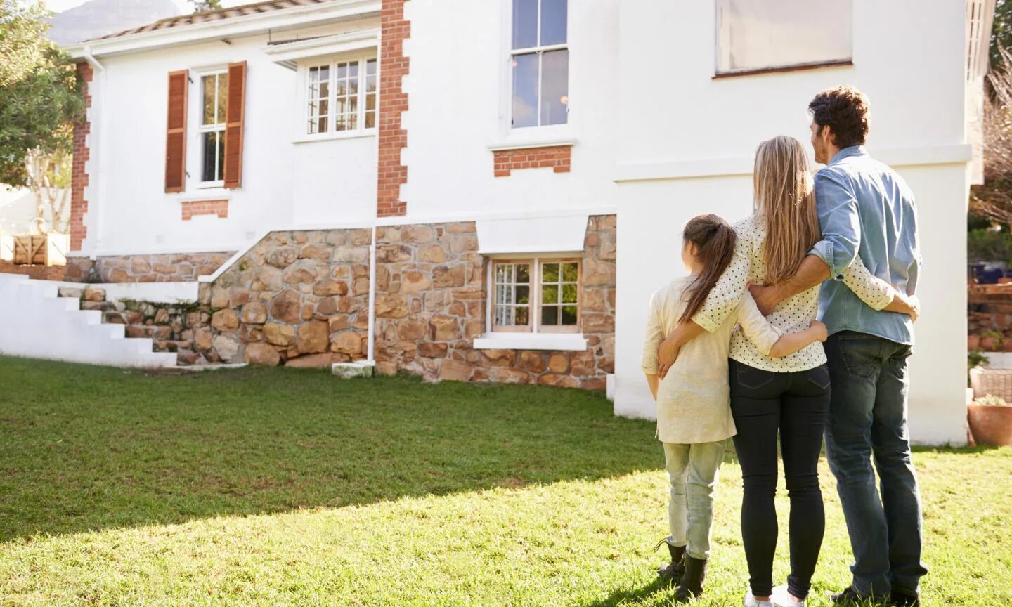 жилье молодым. семья на фоне дома. счастливая семья в доме. руки домиком. молодые семьи жилье.