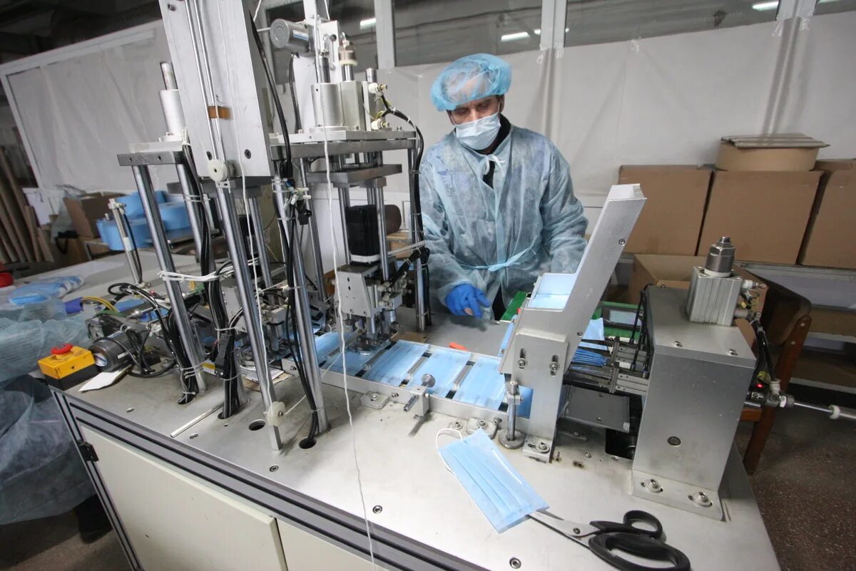 Рабочий в маске. Аппарат для защитного стекла. Маски защитные на заводе. Медицинское производство. Производство защитных.