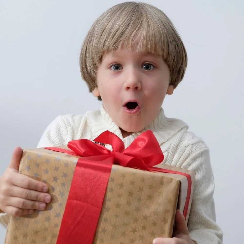 Открытая книга ребенок удивлен. Как удивить детей книгой. Surprised kid with a book. Ребенок дарит подарок. Мальчик с подарочной коробкой в руке.