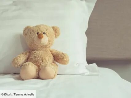 The teddy bear is the bed